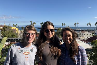 From left to right: Chessa, Madison, and LuLing in front of a view of the Santa Cruz wharf